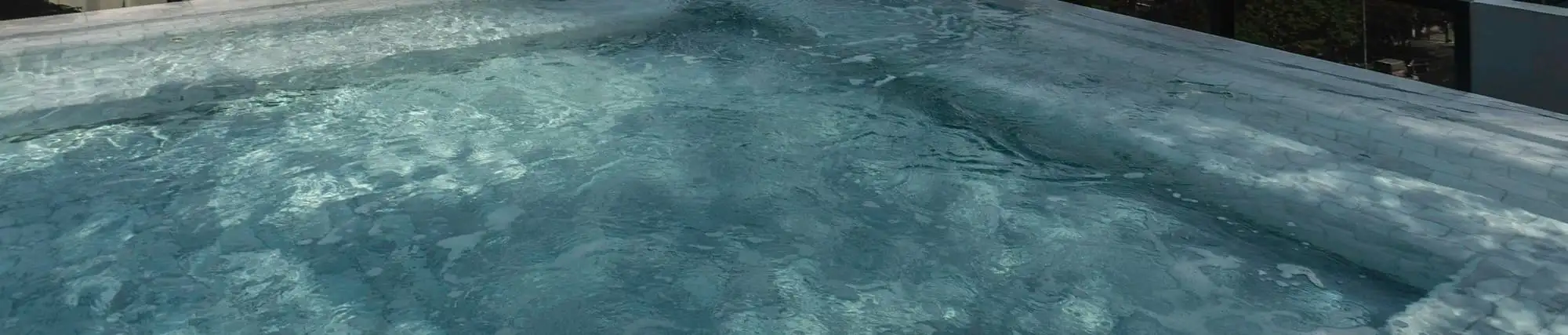 Clear water in the rooftop plunge pool, rippled by the afternoon light.